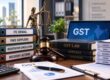 Legal desk featuring a gavel resting on GST Law books, a laptop displaying GST, Lady Justice, and binders labeled ITC Denial, Fake Suppliers, Registration Cancellation, and Recovery Actions.